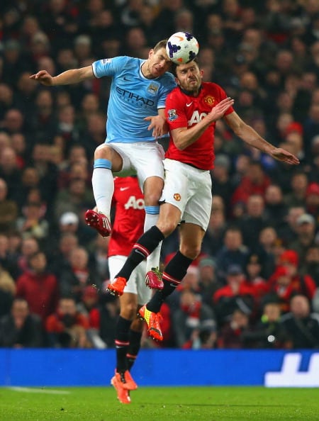 MANCHESTER, ENGLAND - MARCH 25: Michael Carrick of Manchester United goes up for a header with Edin Dzeko of Manchester City during the Barclays Premier League match between Manchester United and Manchester City at Old Trafford on March 25, 2014 in Manchester, England. (Photo by Alex Livesey/Getty Images)