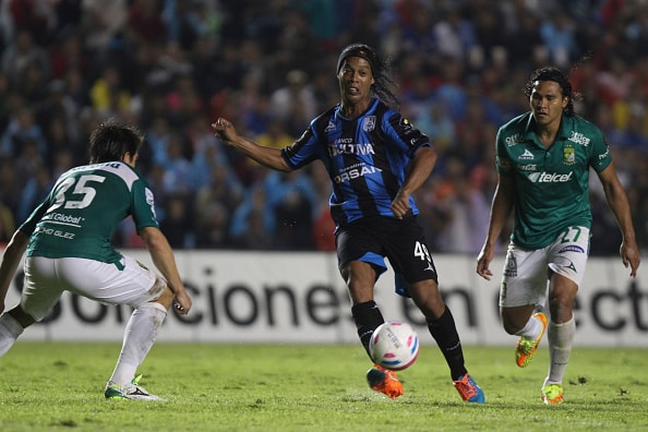 QUERETARO, MEXICO - OCTOBER 1: Ronaldinho (L) of Queretaro and Carlos Pena (R) of Leon vies for the ball during the match between Queretaro and Leon as part of the Bancomer League Apertura 2014 tournament, held at the Corregidora stadium on October 3, 2014 in Queretaro, Queretaro, Mexico. (Photo by Edgar Quintana/LatinContent/Getty Images)