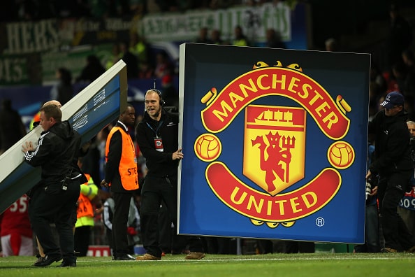 MANCHESTER, ENGLAND - SEPTEMBER 30: UEFA Champions League workers hold up a logo of Manchester United during the UEFA Champions League match between Manchester United and Wolfsburg at Old Trafford on September 30, 2015 in Manchester, United Kingdom. (Photo by Matthew Ashton - AMA/Getty Images)